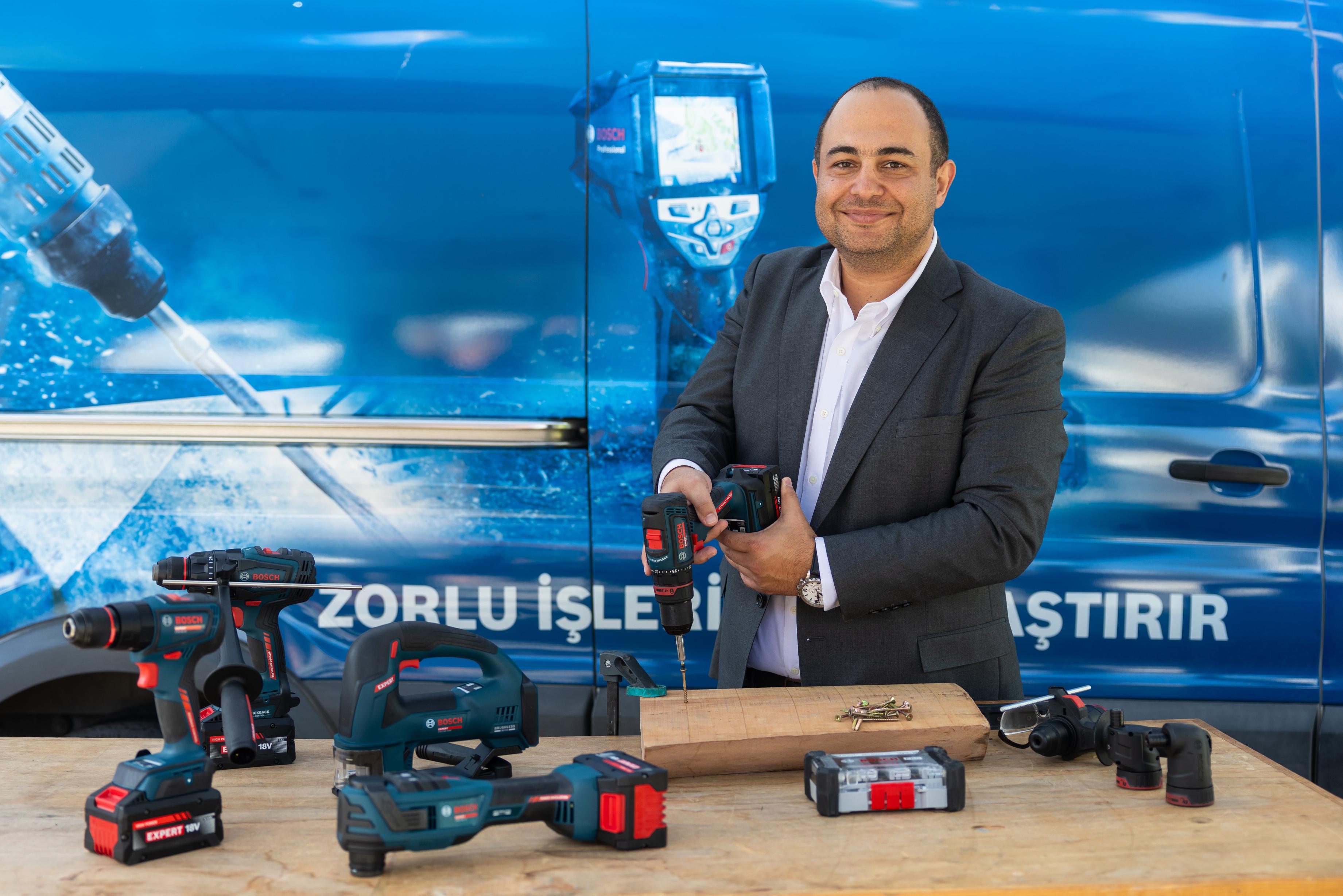 Ali Fahri Özcan, EXPERT 18V akülü aletlerin sergilendiği Bosch Professional aracının önünde bir vidalama makinesini tanıtırken